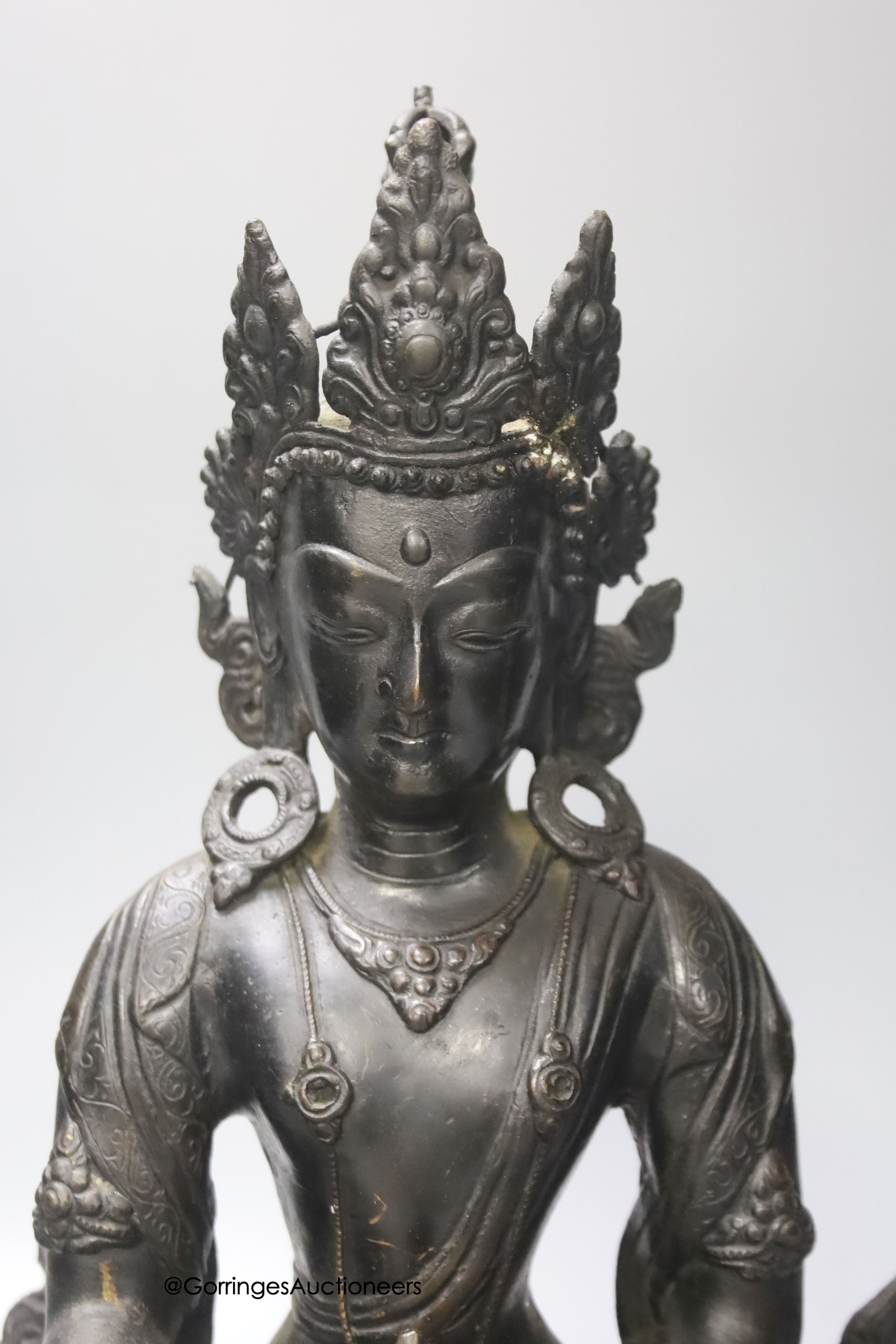 A bronze figure of a Bodhisattva, seated on an oval lotus base, 36cm